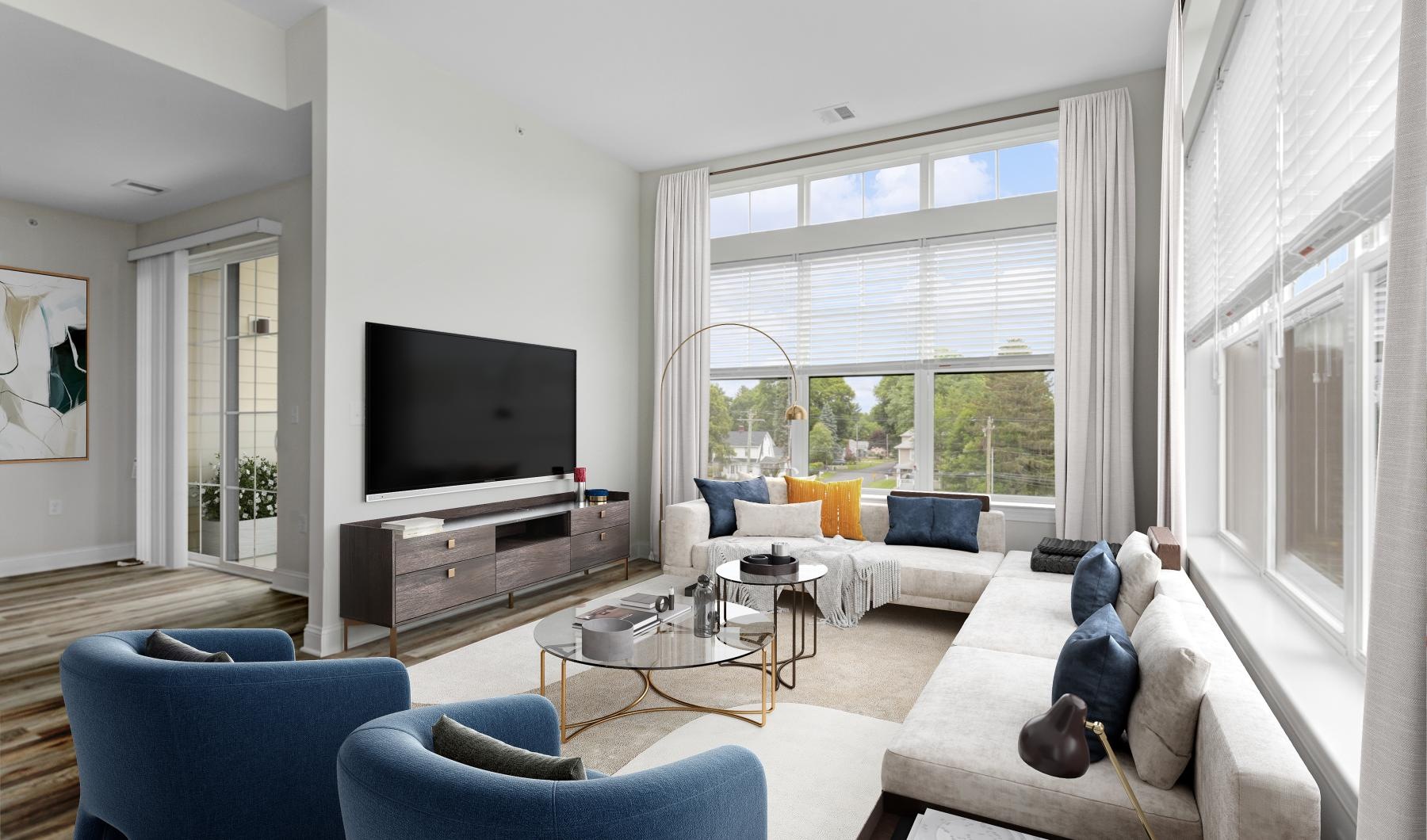 Generous living spaces with beautiful natural lighting a living room with a tv and couches